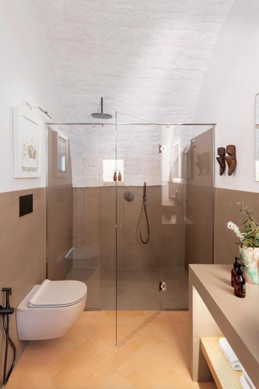a bathroom with a toilet and a glass shower at Masseria Auraterrae in Polignano a Mare