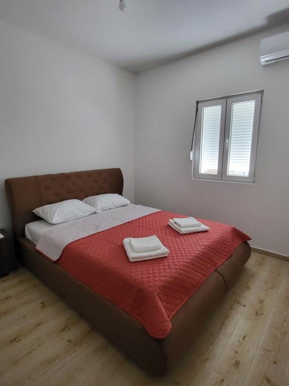 una camera da letto con un grande letto con due asciugamani di Novi Relax apartment a Herceg-Novi