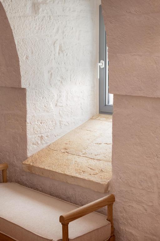 a staircase in a white walled room with a window at Masseria Auraterrae in Polignano a Mare