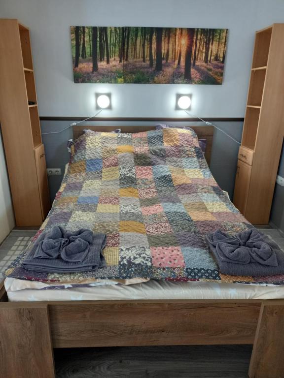 a bed with a quilt on top of it at Kiskassa Vendégház 