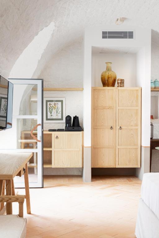 a living room with a wooden cabinet and a table at Masseria Auraterrae in Polignano a Mare