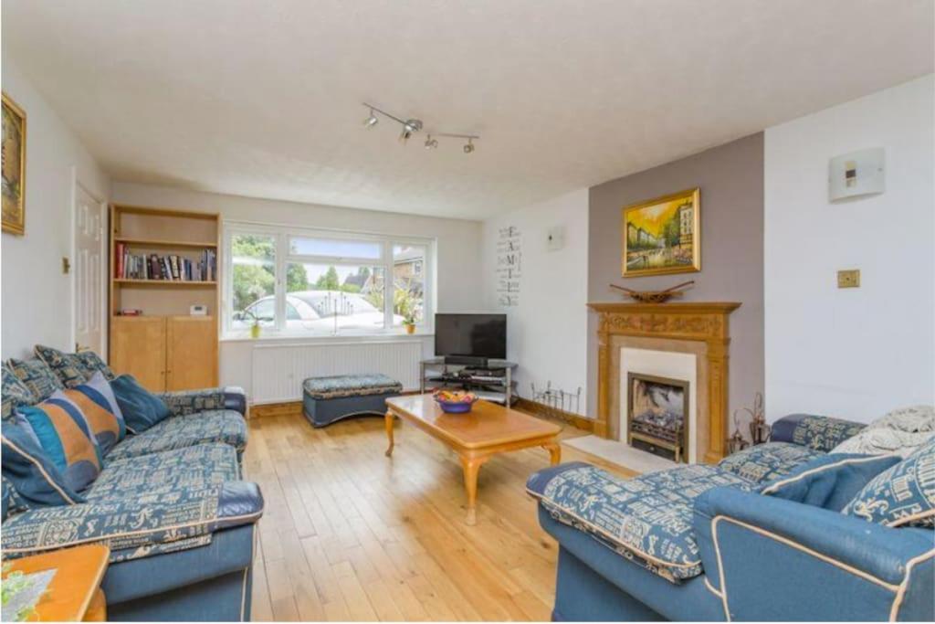 Roffey的住宿－Spacious 5 Bedroom 11 Guest Family House in Horsham，客厅配有2张蓝色沙发和壁炉