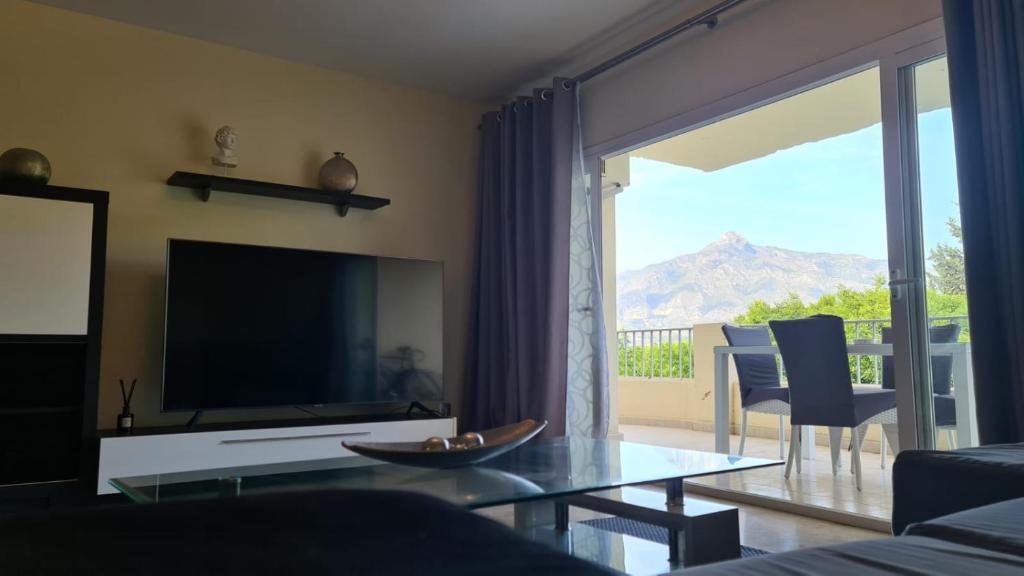 a living room with a tv and a glass table at Jardines de Banús Apartments in Marbella