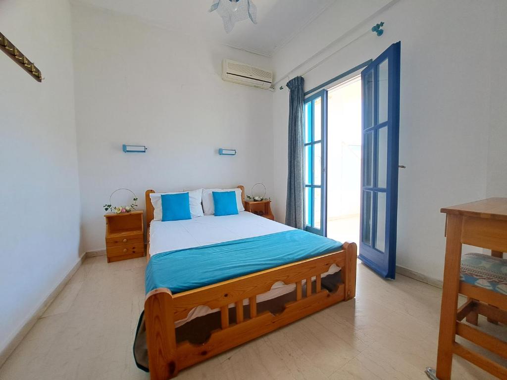 a bedroom with a bed and a large window at Apollonia Apartments in Agia Pelagia