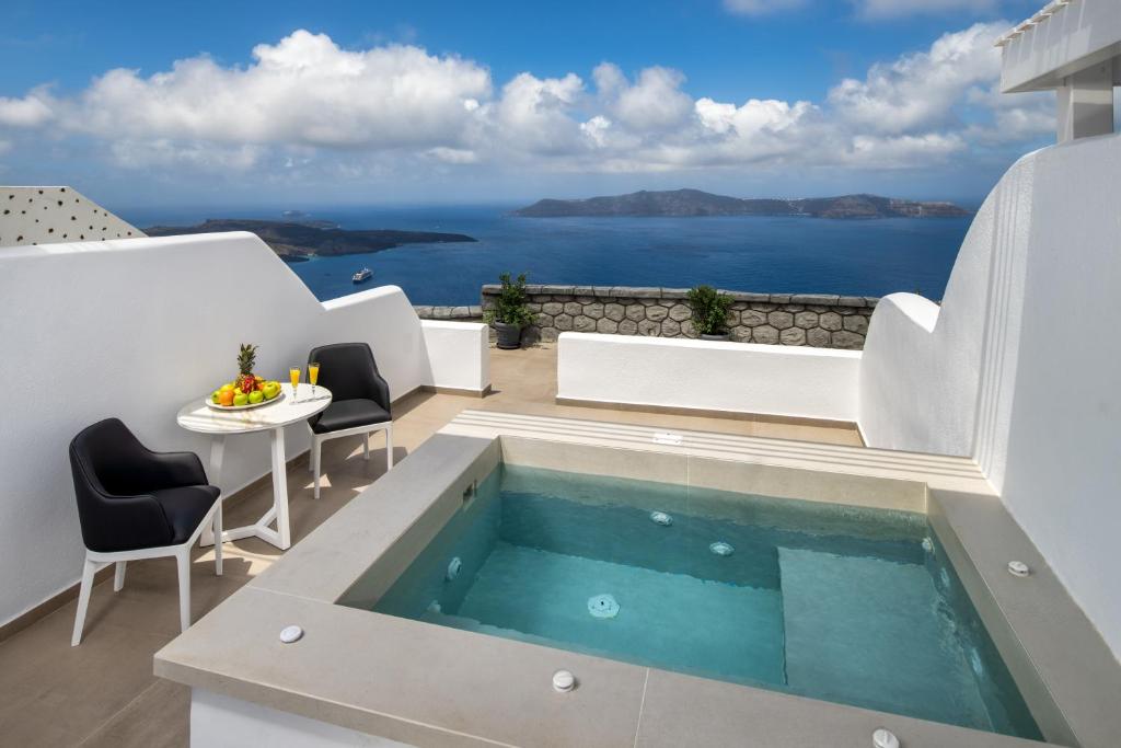 a house with a swimming pool with a view of the ocean at Aura Suites in Firostefani