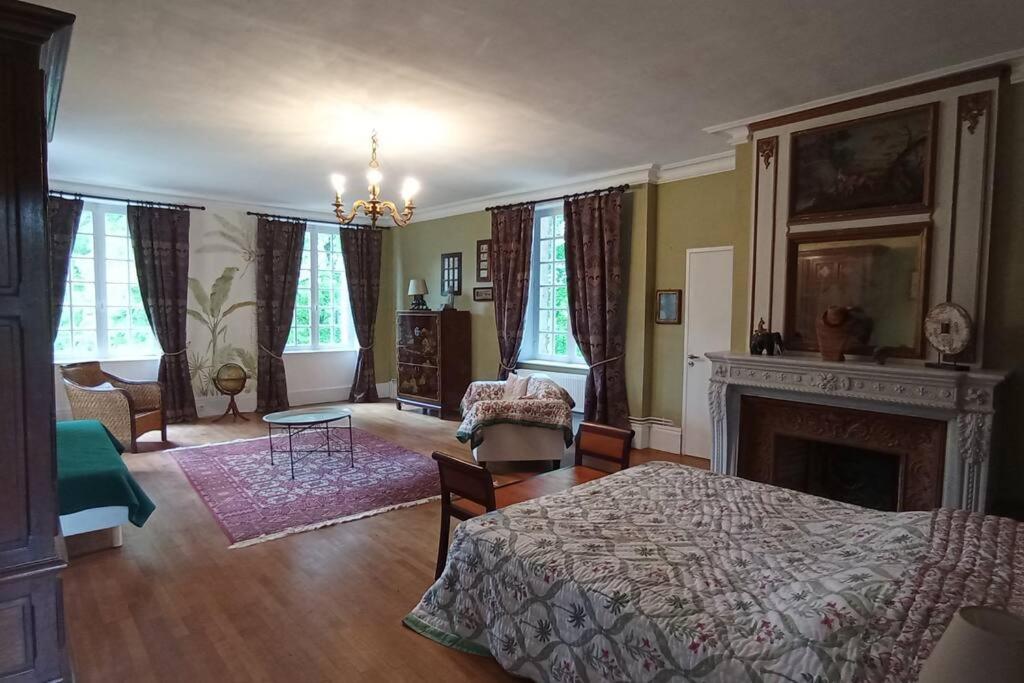 a bedroom with a bed and a fireplace at Château de Heuqueville in Heuqueville
