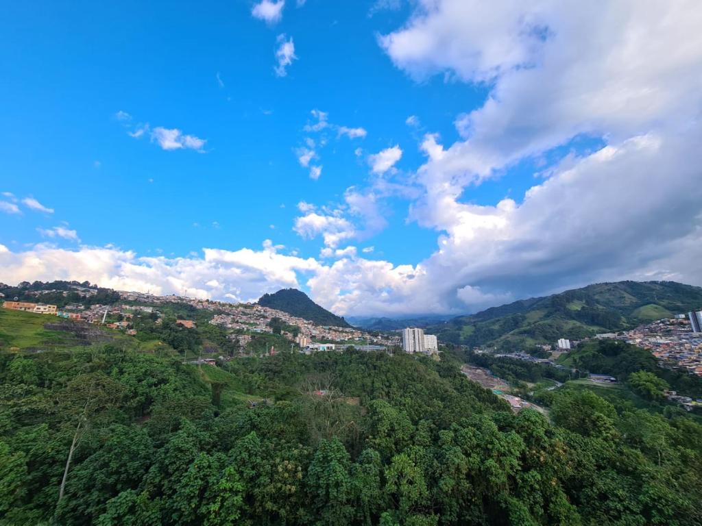 una ciudad en la cima de una colina con árboles en Moderno apartamento con vista a las montañas, en Manizales