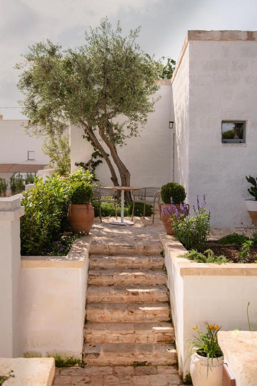 a stone walkway in a garden with a tree at Masseria Auraterrae in Polignano a Mare