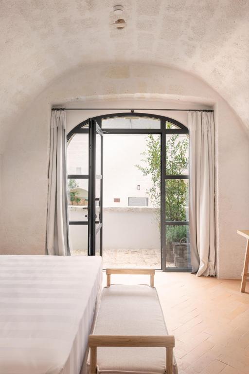 a bedroom with a bed and a large window at Masseria Auraterrae in Polignano a Mare