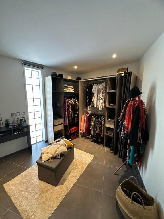 een kamer met een kast met kleren op planken bij Grand appartement de 119m2 avec jardin de 219m2 in Quimper
