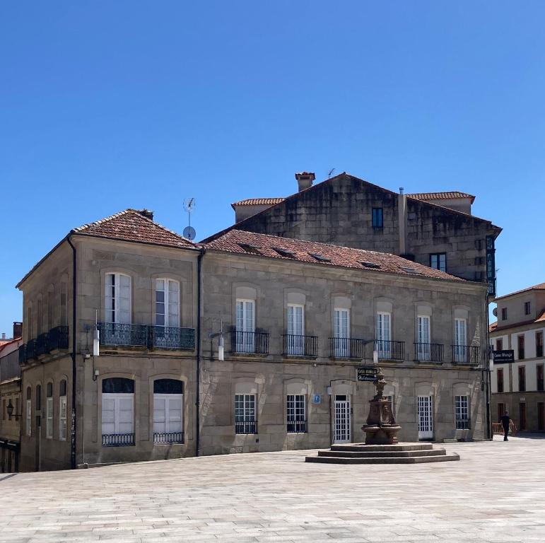 un viejo edificio con una fuente frente a él en CASA MARUXA pensión, en Pontevedra
