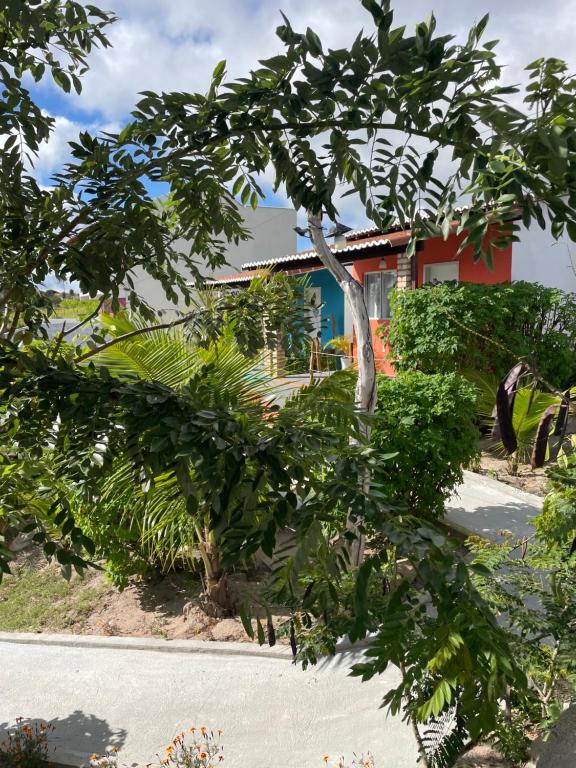 une maison avec un arbre en face d'une rue dans l'établissement Pousada Alto da Serra, à Serra de São Bento