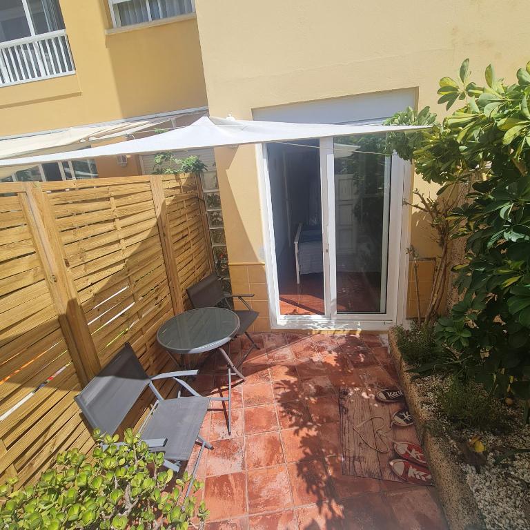 Habitación doble con baño y terraza privada في إل ميدانو: فناء مع طاولة ومظلة