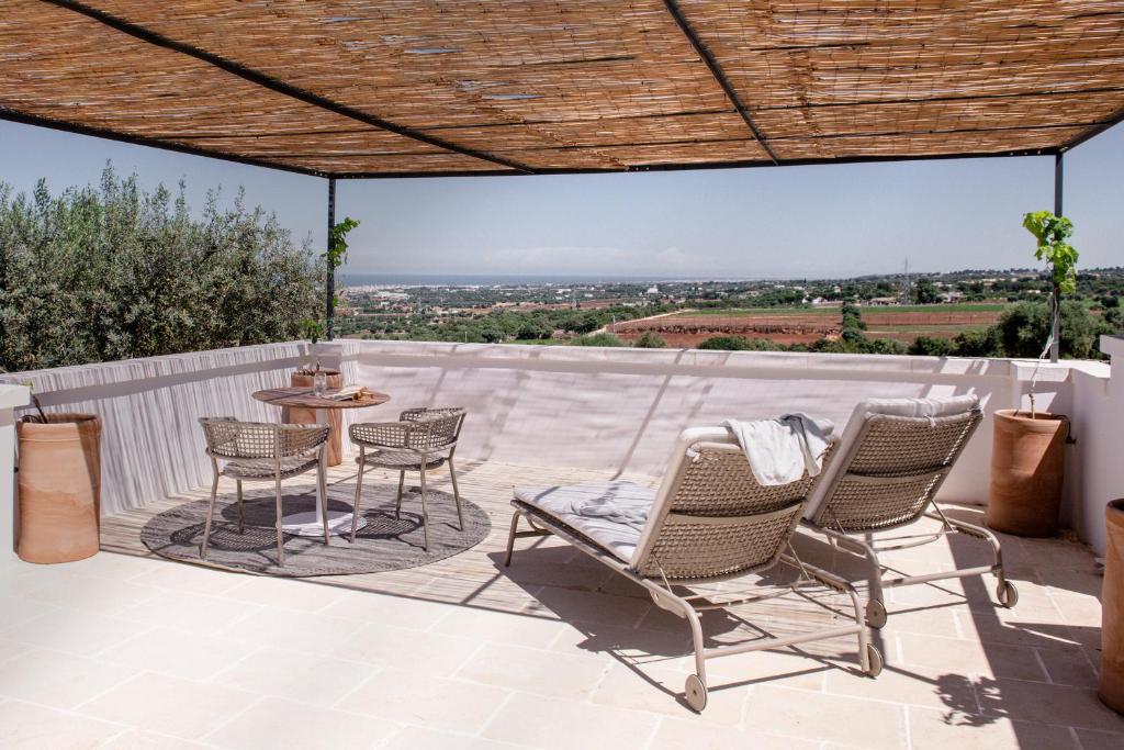 a patio with chairs and a table on a roof at Masseria Auraterrae in Polignano a Mare