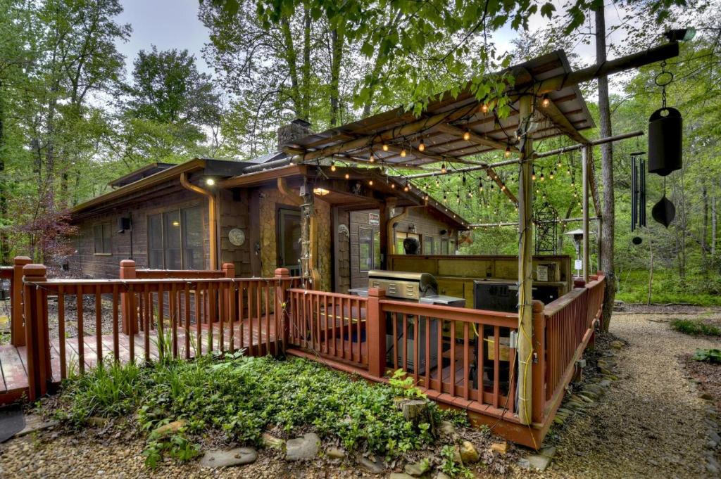 ein kleines Haus mit einer Terrasse mit Grill in der Unterkunft A River Runs Through It in Cherry Log