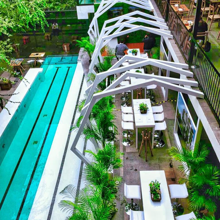 an overhead view of a swimming pool with a white bridge at Hotel Carlota in Mexico City