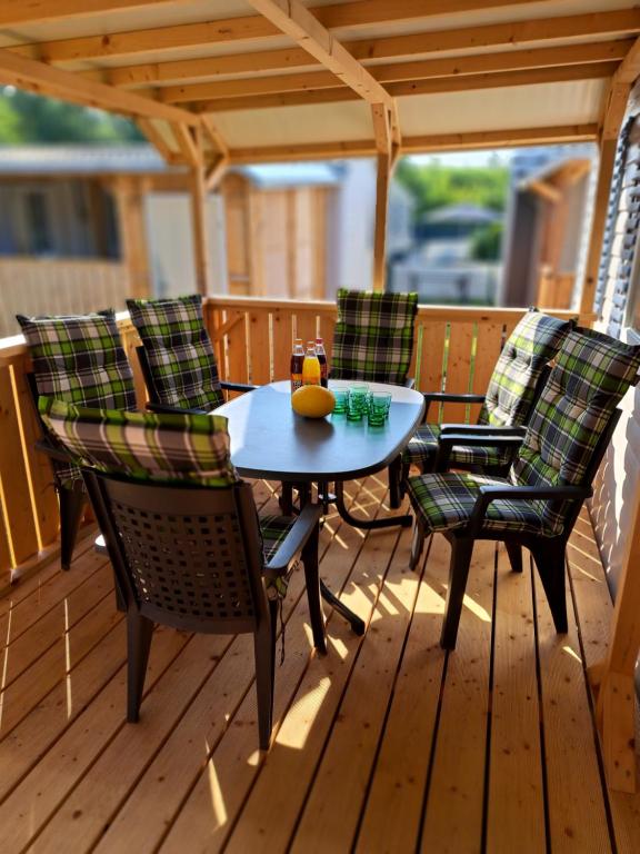 una mesa y sillas en una terraza de madera en Mobilheim / Chalet en Seekirchen Markt