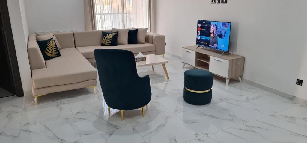 a living room with a couch and a tv at Appartement Sousse Sahloul 4 in Sousse