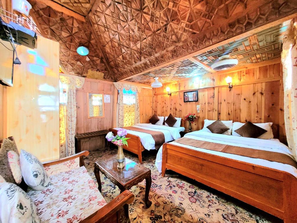 a hotel room with two beds and a couch at Aziz Palace Group Of Houseboats in Srinagar
