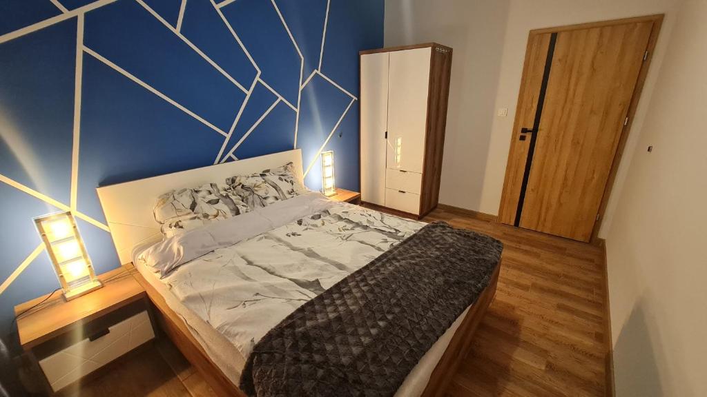 una camera con un letto con una parete blu di Apartament z wodą termalną a Uniejow
