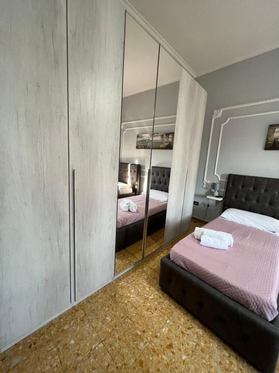 a bedroom with two beds and a mirror at La Casa Di Tonia in Naples
