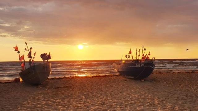 two boats sitting on the beach at sunset at Ferienwohnung Gentzen in Baabe