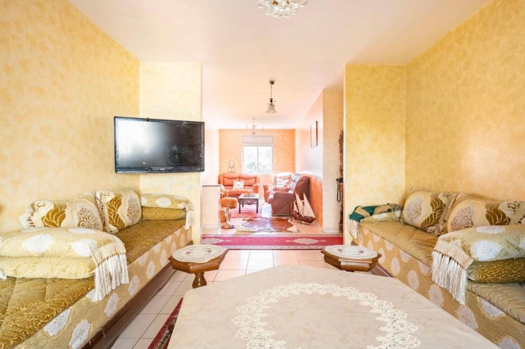 ein Wohnzimmer mit 2 Sofas und einem Flachbild-TV in der Unterkunft Appartement confortable residence koutoubia quartier nassim casablanca in Casablanca