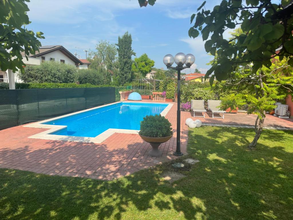 a swimming pool in a yard next to a house at Casa Fanny in Castelnuovo del Garda