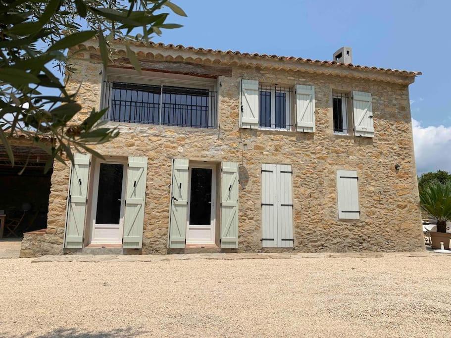 - un bâtiment en pierre avec des portes et des fenêtres blanches dans l'établissement Maison Pipette Pipette Maison, au Castellet