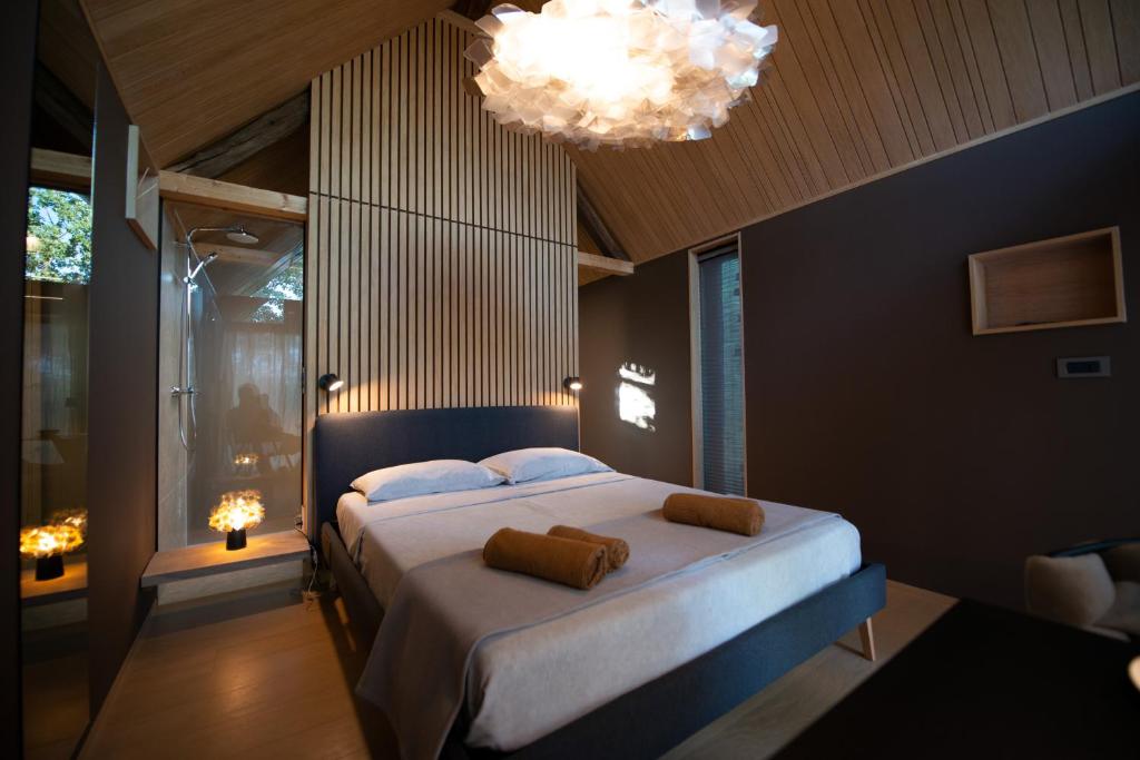 Un dormitorio con una cama grande y una lámpara de araña. en Moon - Tiny house from Callin Wines en Sežana