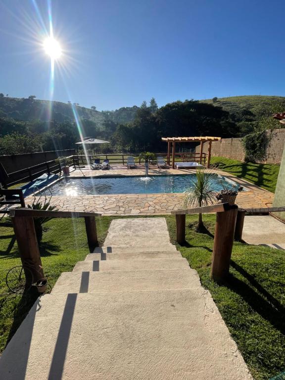 a swimming pool with the sun shining on it at CHÁCARA COM PISCINA CLIMATIZADA e JACUZZI in Socorro