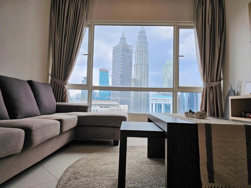 sala de estar con sofá y ventana grande en Crest Residence Klcc Bukit Bintang by Sarah's Lodge, en Kuala Lumpur