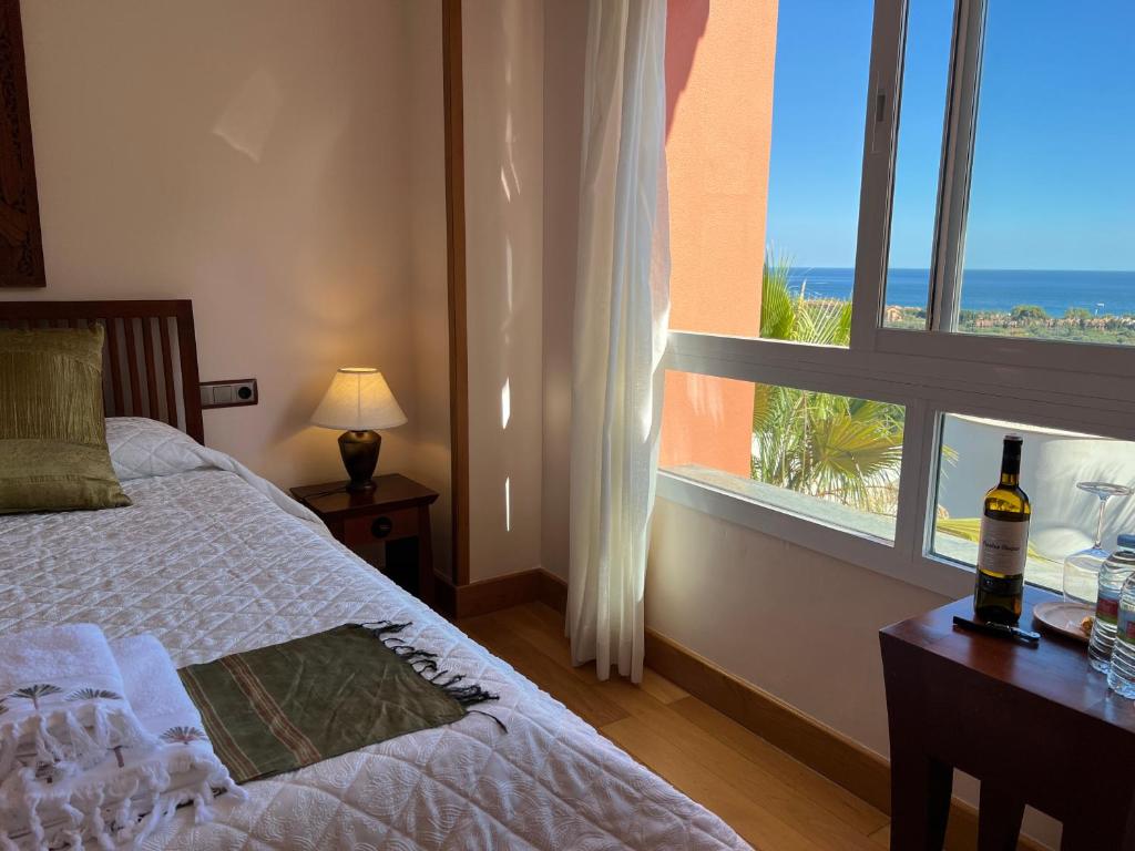 een slaapkamer met een bed en een raam met een fles wijn bij The Marbella Heights Boutique Hotel in Marbella