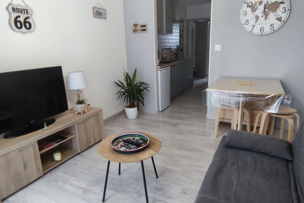 een woonkamer met een televisie en een tafel bij Appartement cosy sur Agde pour 4 personnes maxi. in Agde