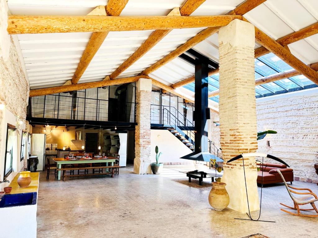 an open living room with exposed ceilings and brick walls at Magnifique Loft - Piscine - Tennis - Babyfoot in Nîmes