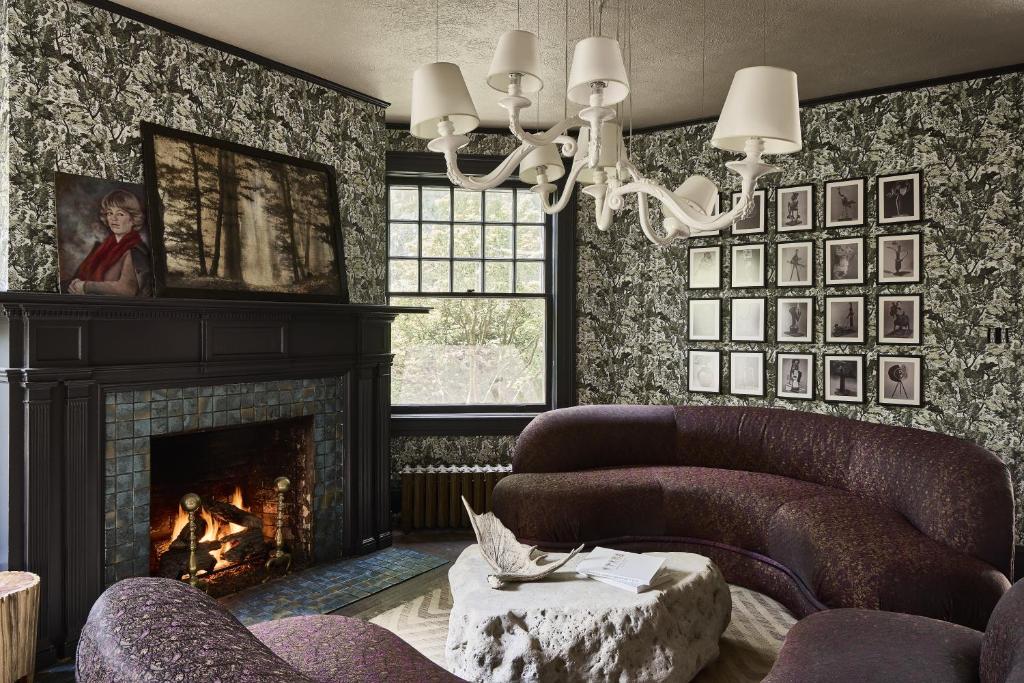 ein Wohnzimmer mit zwei Stühlen und einem Kamin in der Unterkunft Blind Tiger Asheville in Asheville