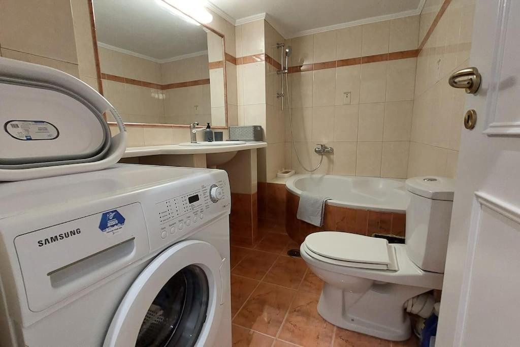 a bathroom with a washing machine and a toilet at Avli House in Heraklio