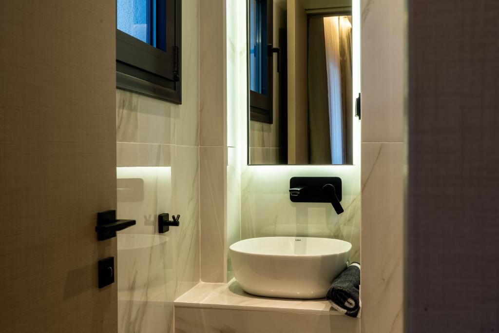 a white sink in a bathroom with a mirror at NERO SEASCAPE SUITES in Fanari