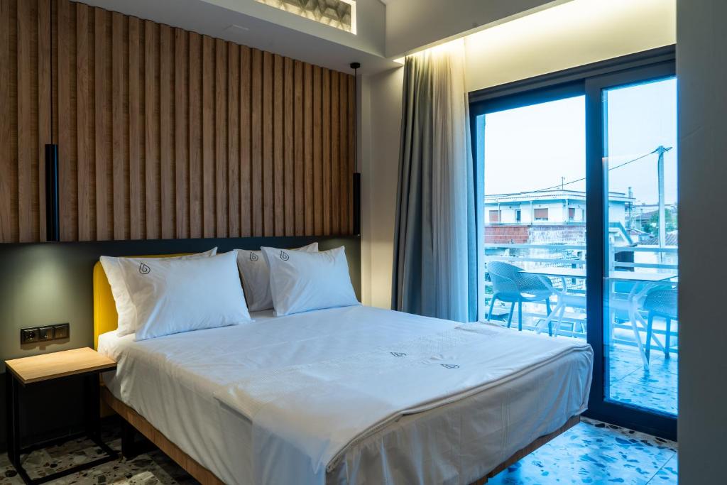 a bedroom with a large bed and a balcony at NERO SEASCAPE SUITES in Fanari