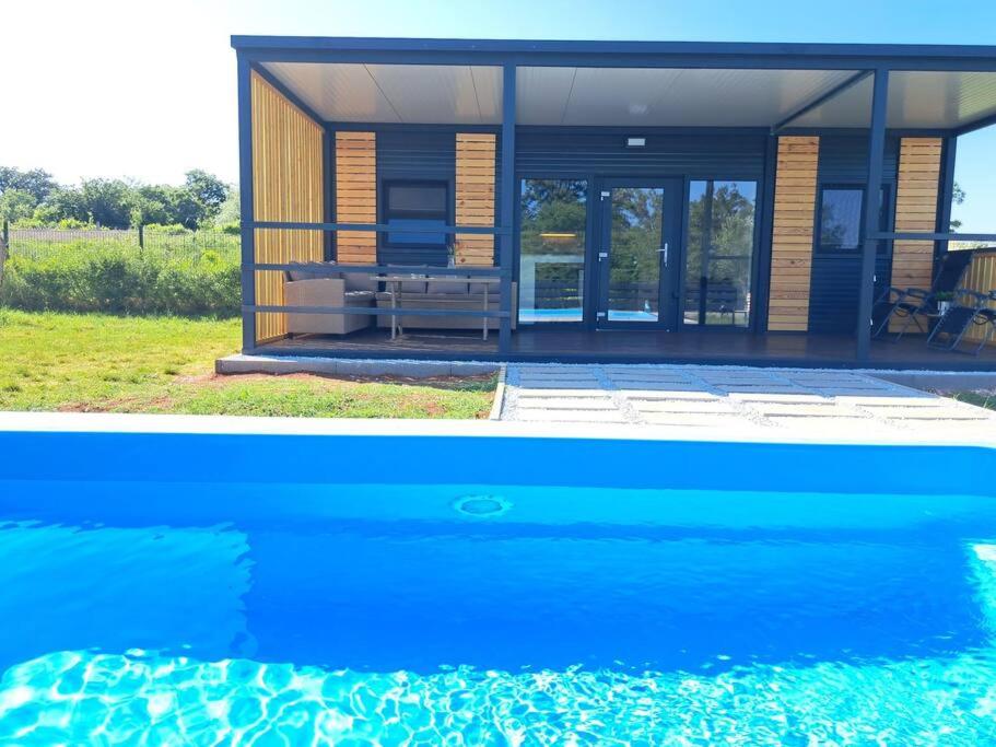 uma casa com uma piscina em frente em Small country house em Manjadvorci