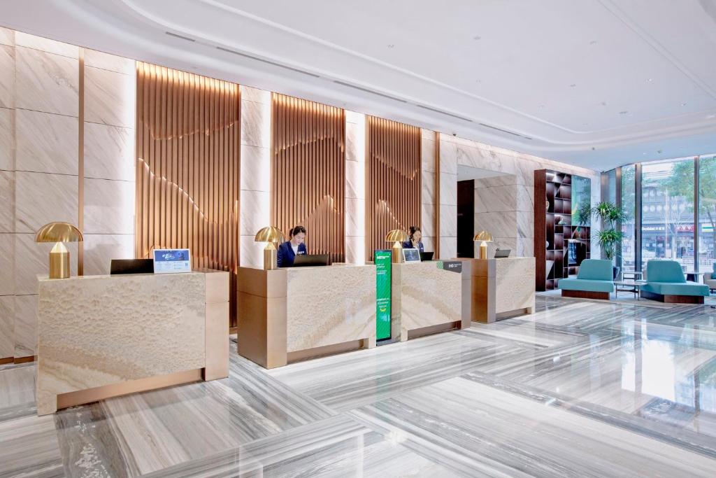 Holiday Inn Taiyuan City Center في تاييوان: لوبي فيه ناس جالسين في مكاتب الاستقبال