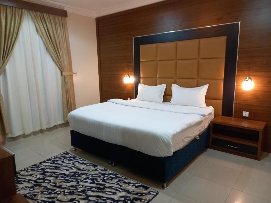 a bedroom with a large bed with a large headboard at الملاك بارك in Taif