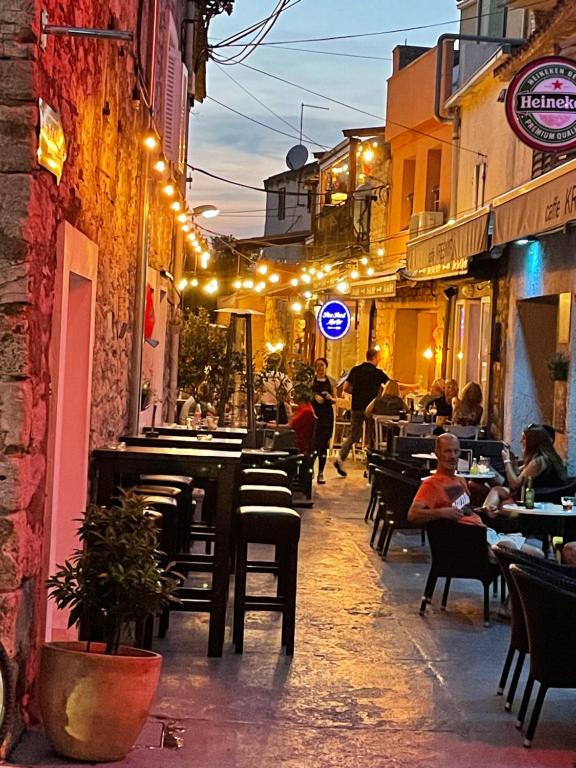 a street with people sitting at tables in a restaurant at Mobile Home Pinija in Jezera