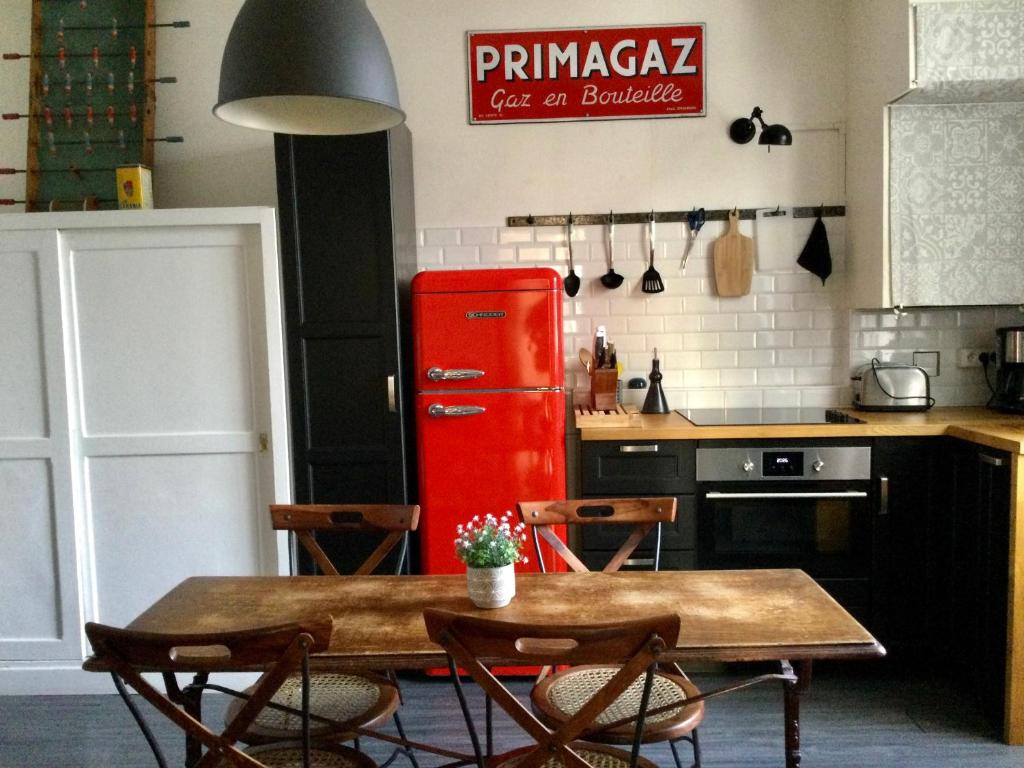 a kitchen with a table and a red refrigerator at L'APPART de 75 m², déco sympa à Tours in Tours