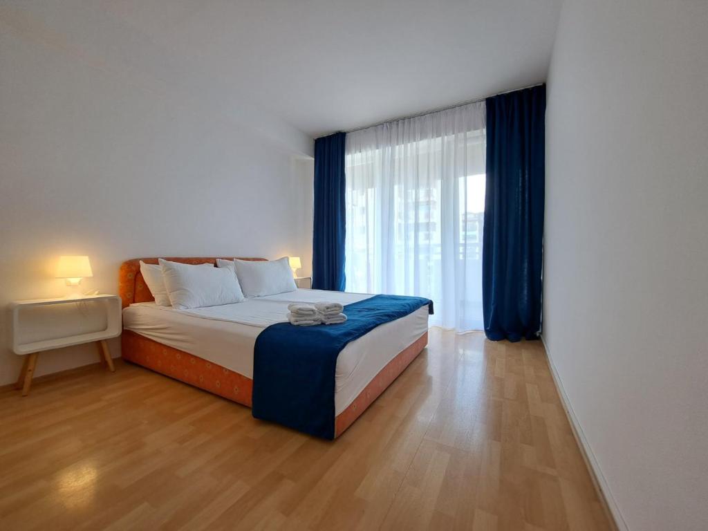 ein Schlafzimmer mit einem Bett und einem großen Fenster in der Unterkunft 4M Apartments in Ohrid