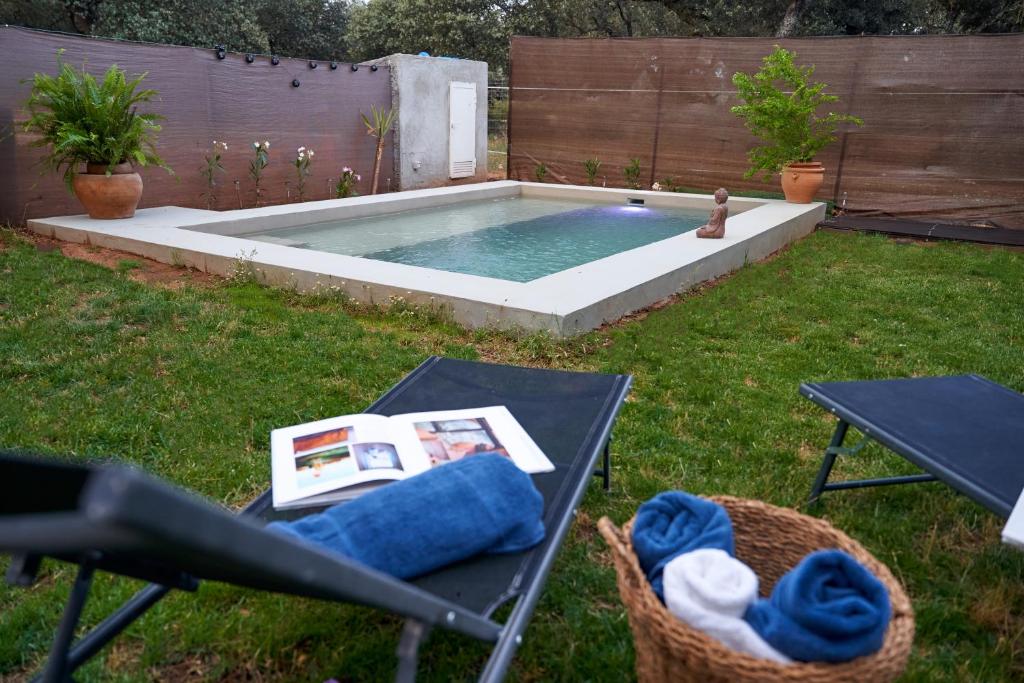 una piscina en un patio con una mesa y una sidra de picnic en Cabaña Rural El Arbol near Setenil - Ronda con piscina en Ronda