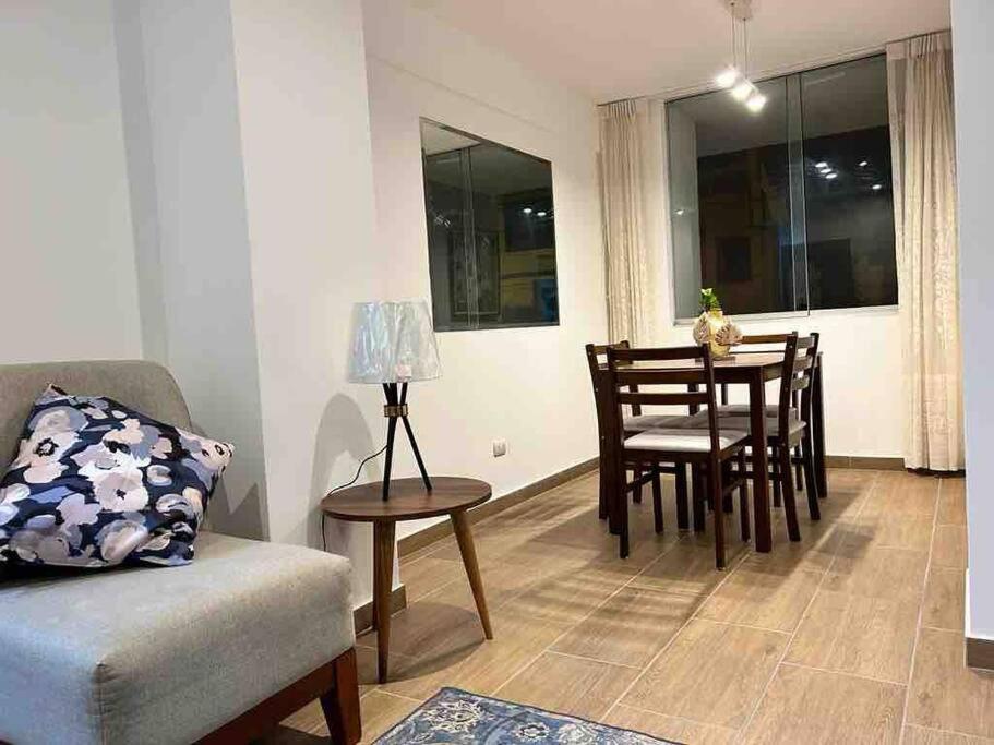 een woonkamer met een tafel en stoelen en een eetkamer bij Cozy Family Full Apartament Excelent WIFI in Lima