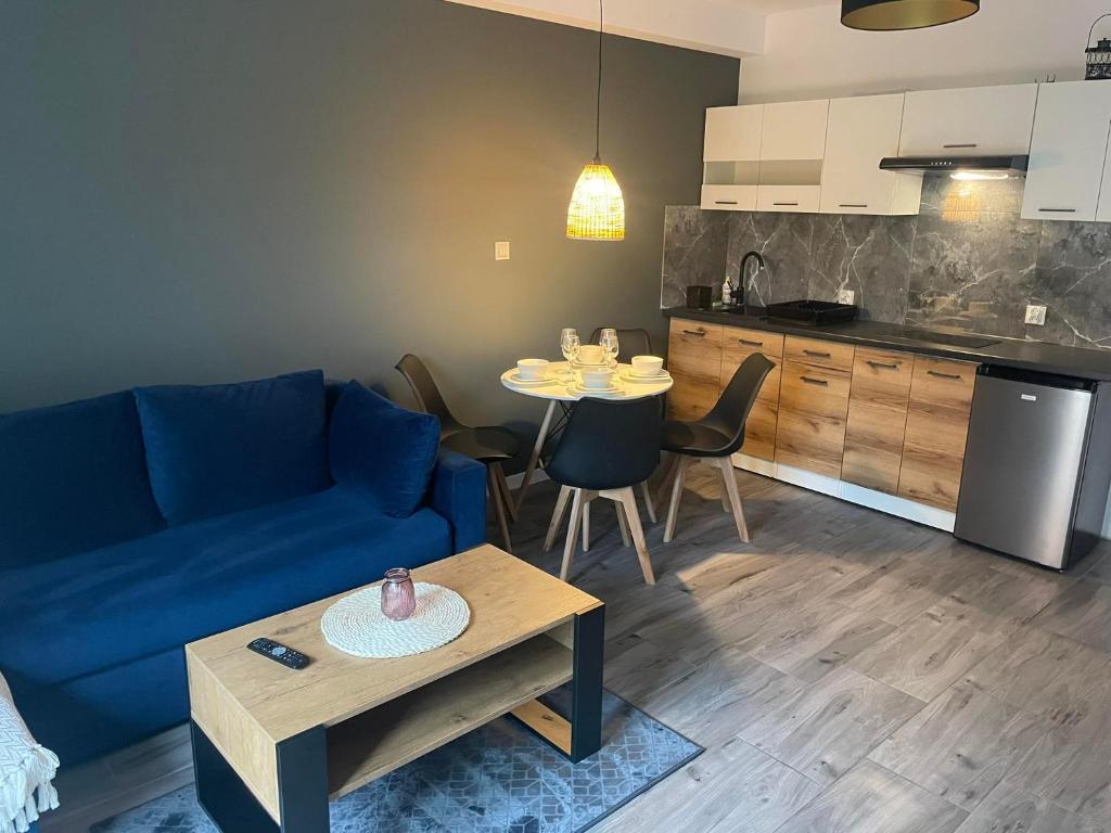 sala de estar con sofá azul y mesa en Pokoje I Apartamenty Polna 19 en Niechorze