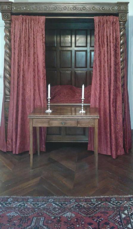 une table en bois avec deux bougies sur un lit dans l'établissement Chambre d'hôte d'une maison de chanoine - pas un hôtel, 2e étage, 3 pièces 90m2, à Autun