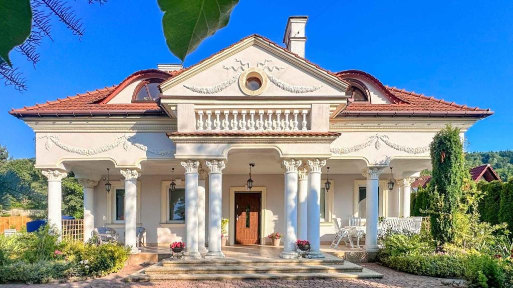 una gran casa blanca con techo rojo en Zielone Zarabie Residence en Myślenice